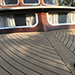 Classic motorboat swept deck with snapes to a king plank using Permateek Synthetic Decking in 'Traditional' with black caulking.